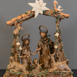 Photo of a clay Nativity scene from Portugal featuring the Holy Family within a stable. An ox, donkey, and rooster look upon them. 