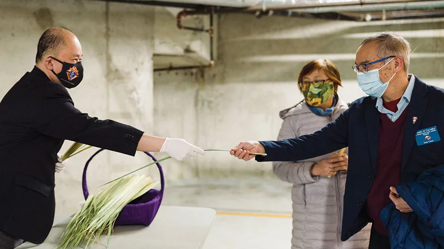 Webster Licaros, Marcus Wong and Vance Licaros (left to right) of St. Francis Xavier Council 10500 dish up meals April 10 to deliver to The Door is Open, an archdiocesan ministry that supports people experiencing homelessness.