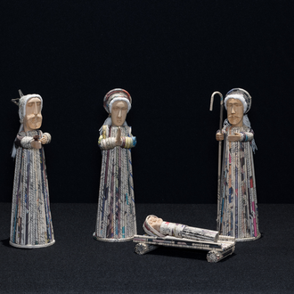 Photo of a Nativity scene made of wood and rolled newspaper featuring figures of the Holy Family and 3 Magi.
