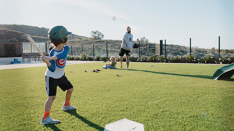 Trevor Williams pitches a wiffle ball to his son Isaac in their backyard in San Diego