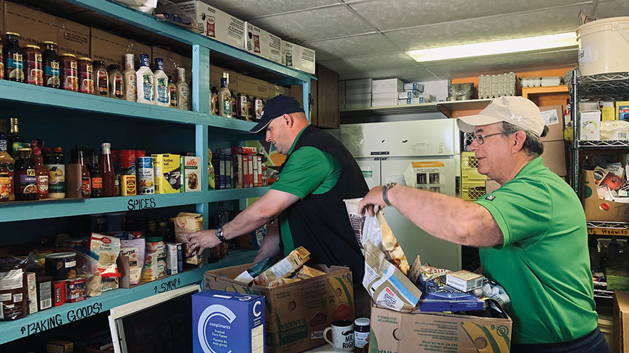 Saskatchewan State Deputy Chris Bencharski (right) and Grand Knight Kevin Rutt of Meadow Lake Council 5259 sort groceries at Door of Hope, a food pantry in Meadow Lake that serves many indigenous clients.