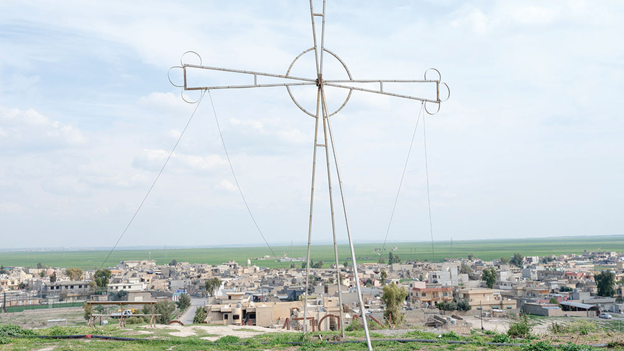 Father Thabet Habib Yousif views the damage to his parish