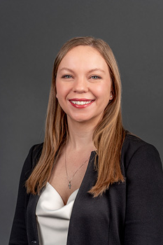 Headshot of Sarah Hochstatter, who smiles while wearing a cream blouse and black blazer suit