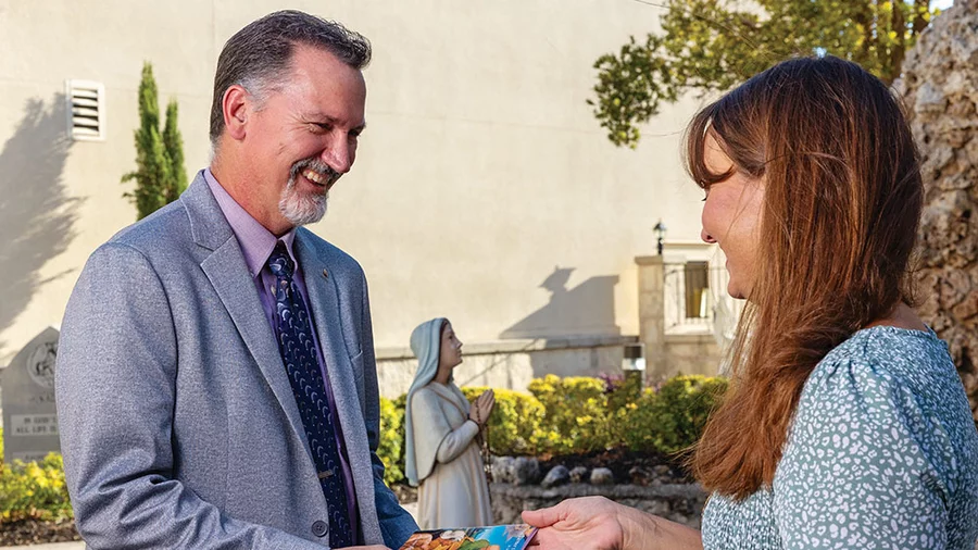 Michael Parma, Catholic Information Service coordinator for New Braunfels (Texas) Council 4183, gives a CIS booklet to a parishioner at Sts. Peter and Paul Church. Parma regularly stocks the CIS resources rack in the church vestibule.