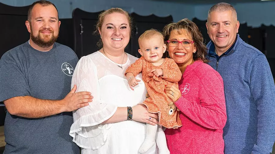 Jordan and Gabrielle Bullard hold their baby, Lynne Marie, together with Monica Kelsey, founder of Safe Haven Baby Boxes, and her husband, Joe, in Woodburn, Ind. (Photo by Jason Mann)