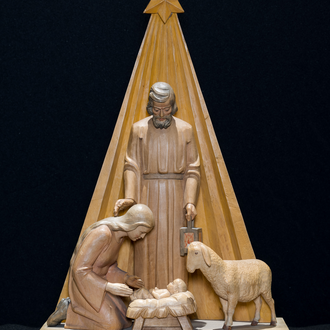 Image of a wood carved Nativity featuring the Holy Family and a sheep standing before a star and its radiating beams. 