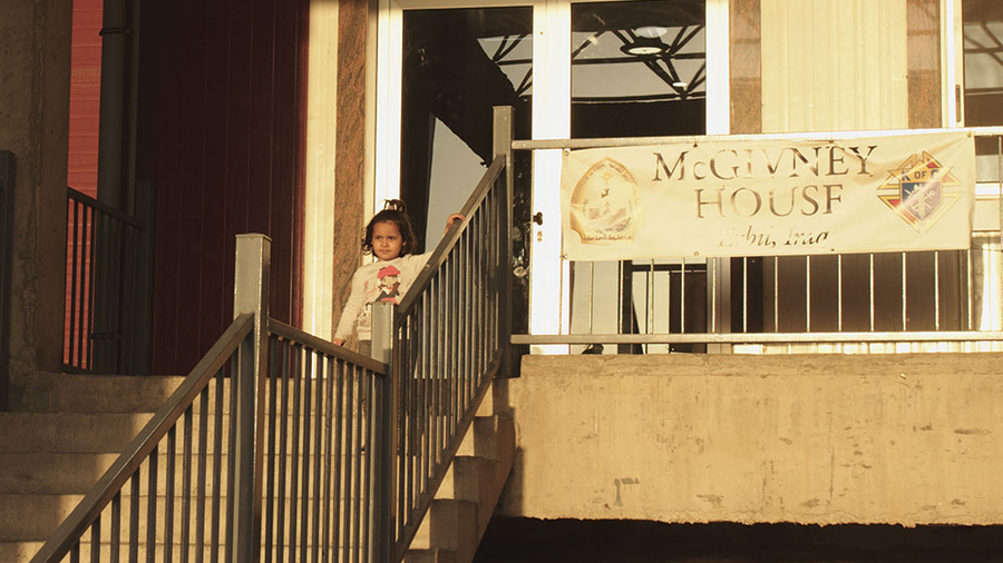 A child plays outside the entrance of McGivney House