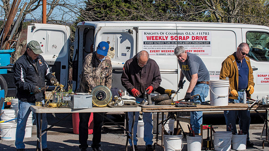 Grand Knights Bill Traube (second from right) and other Knights sort items containing metal donated during a collection at Holy Family Parish in Middletown, Md. (Photo by Matthew Barrick)