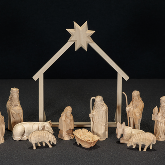 Wood carved Nativity with the Holy Family in front a stable frame. Flanking the stable are 3 Magi, a Shepherd, donkey, ox, and two sheep.