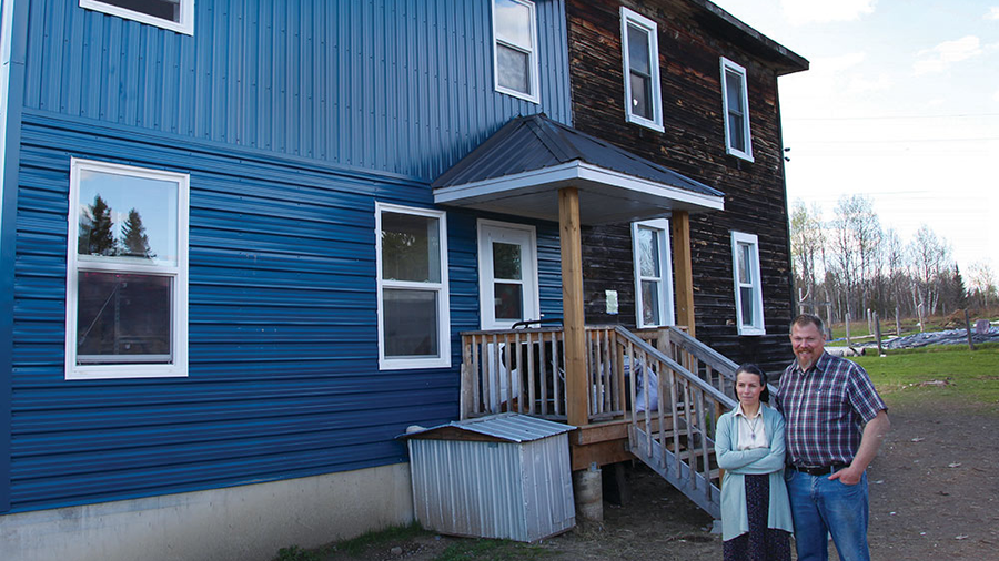 Marc and Carole Jobin stand with Marie-Ange in their new home addition, built with help from Marc’s brother Knights. (Photo by Kenton E. Biffert)