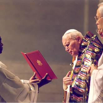Le pape au Vatican, debout avec deux autres personnes, célébrant la messe de minuit.