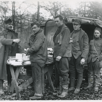 Taken somewhere in the Argonne Forest during days of the war, doughboys wait their turn for free cigarettes, candy, or a rosary handed out by "Casey."