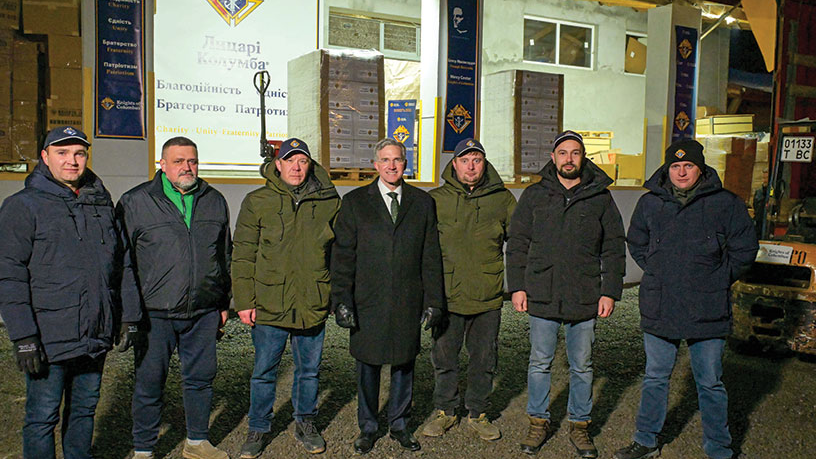 Knights in Lviv, Ukraine, gather with the supreme knight Dec. 6 outside of the warehouse that regularly receives pallets of care packages and other goods delivered by K of C Charity Convoys from Poland. Photo by Tamino Petelinšek