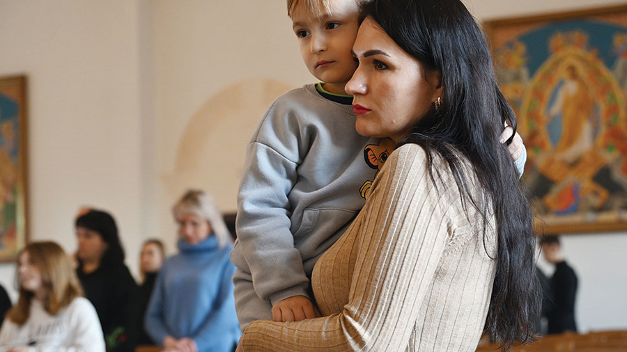 A woman holds her son during a Divine Liturgy in the chapel of the Ivano-Frankivsk Theological Seminary Dec. 30. The liturgy for families of fallen soldiers was organized by Holy Martyr Josaphat Council 18318. (Photo by Andrey Gorb)
