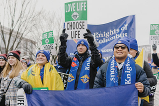 College Knights walk toward the Supreme Court building with thousands of other marchers on Jan. 21, 2022.