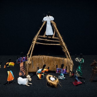 Nativity scene which includes the Holy Family and numerous onlookers in colorful clothing.